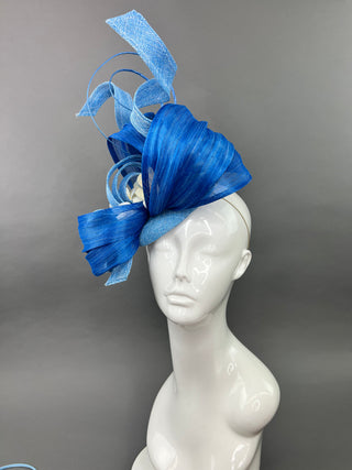 SHADES OF BLUE FASCINATOR WITH CREAM ACCENTS.