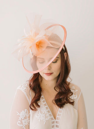 Peachy pink mesh Celeste fascinator, warm coral tones for garden weddings - The Hat Hive