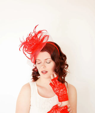 Red fascinator with feathers on headband, ideal for weddings, races, and special occasions